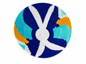 Handwoven sisal wall basket featuring a bold blue and white geometric design with teal and orange accents.