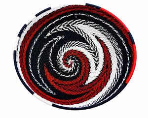 Red, white, and blue woven basket with a spiral pattern. Decorative round bowl for patriotic home decor.