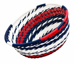 Decorative red, white, and blue woven basket bowl with a nautical striped pattern for home organization.
