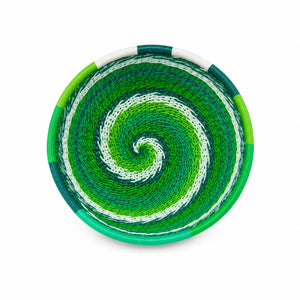 Round woven basket featuring a vibrant green and white spiral pattern, handcrafted for home decor.