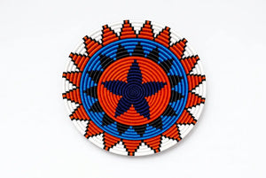 Vibrant Zulu telephone wire basket with a central blue star and orange, black, and white geometric patterns.