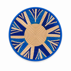 Hand-woven blue and natural beige wall basket with a geometric sunburst design, ideal for artisanal home decor.